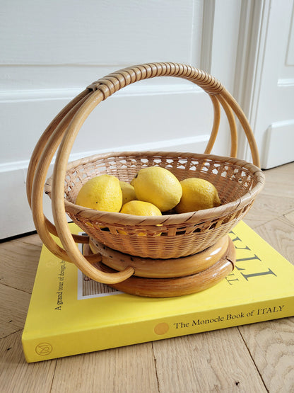 side view of a wicker and rattan fruit basket filled with lemons