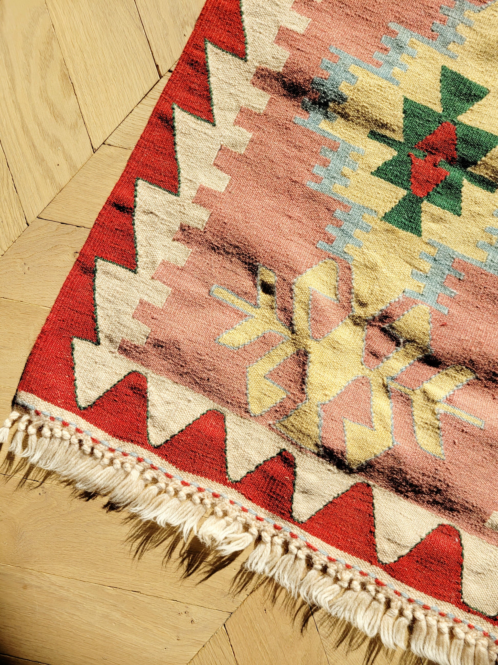 detail of a bright and colourful vintage kilim rug with geometrical pattern