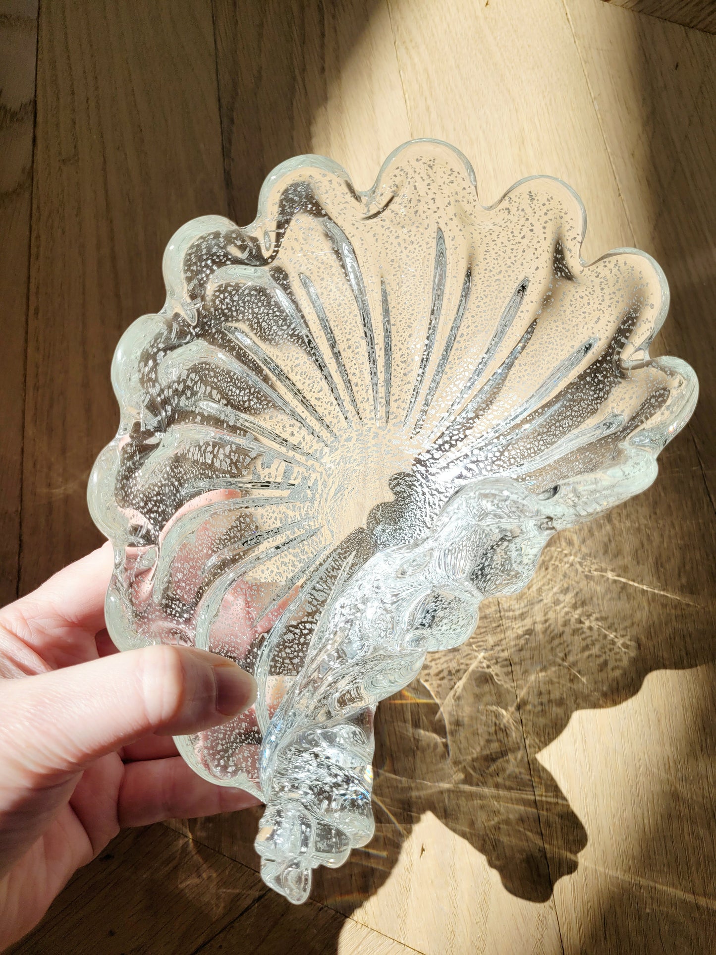 detail of a vintage clear and silver Murano bowl in shell shape 