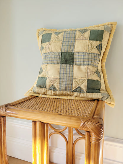 front view of quilted cushion in green and yellow hues and pattern