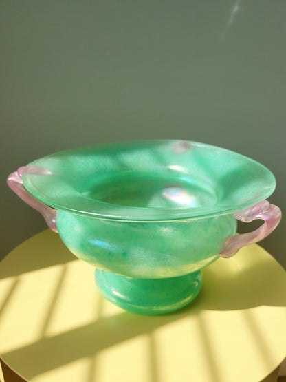 top view of a scavo Murano glass amphora vase in green and pink on a yellow side table