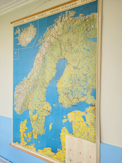 side view of a large historic school map of the Nordic countries hanging on a blue and yellow wall
