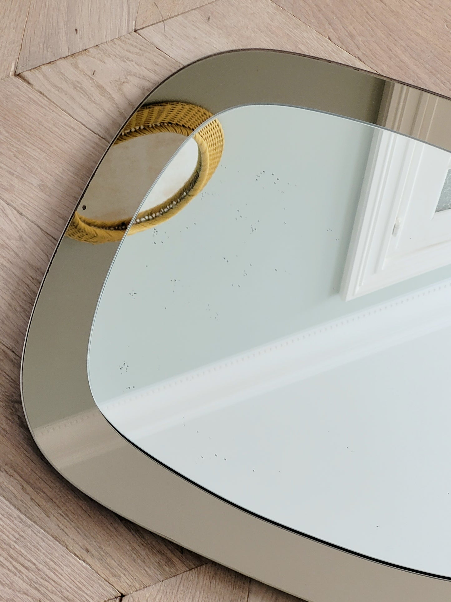 detail of a vintage two-tone Italian wall mirror with smoked glass