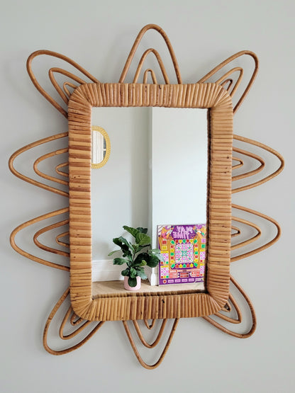 front view of a playful vintage wall mirror with rattan frame
