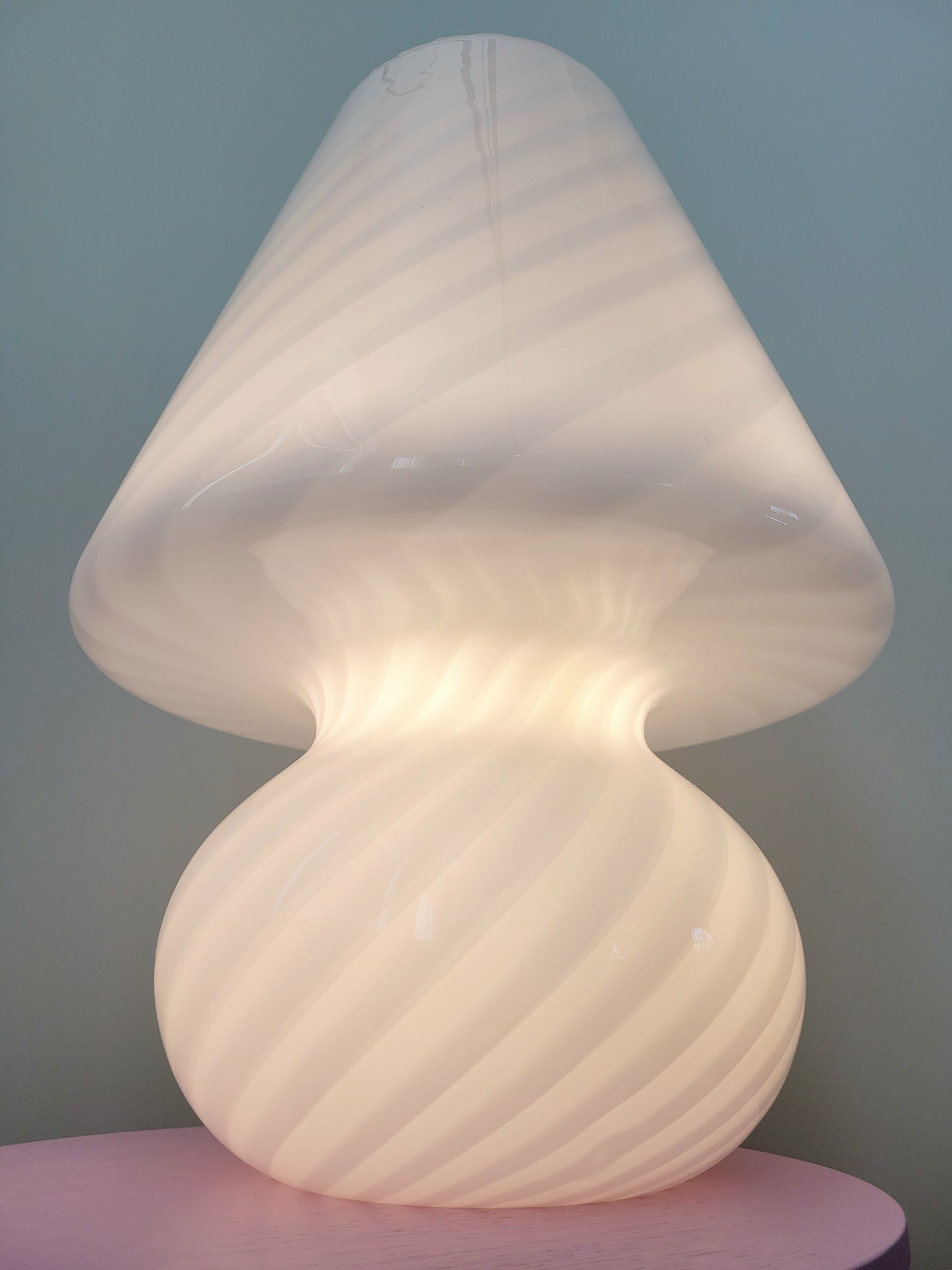 bottom view of an extra large vintage Murano white swirl mushroom lamp illuminated