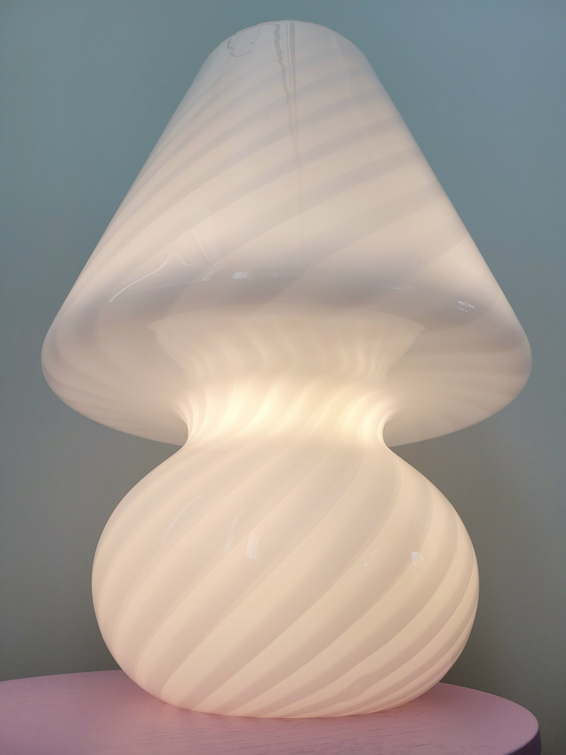 bottom view of an extra large vintage Murano white swirl mushroom lamp illuminated