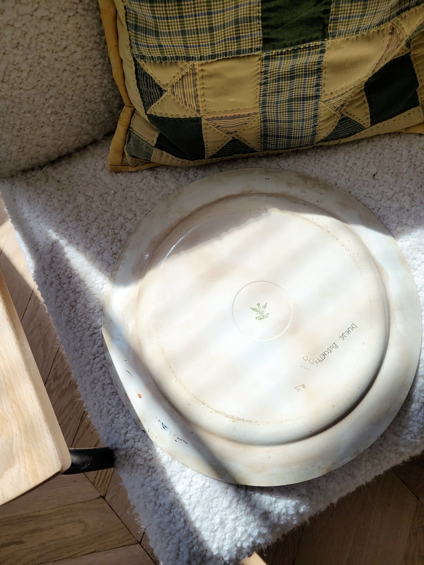 back view of a signed vintage Italian (wall) plate with blue and green floral motif, made by Fontebasso Treviso, Italy on a white chair