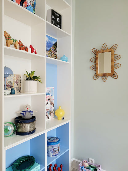 front view of a playful vintage wall mirror with rattan frame