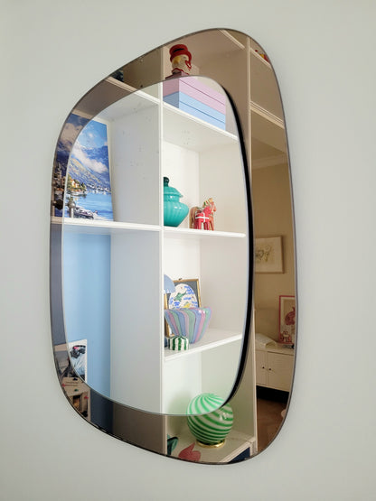 full view of a vintage two-tone Italian wall mirror with smoked glass