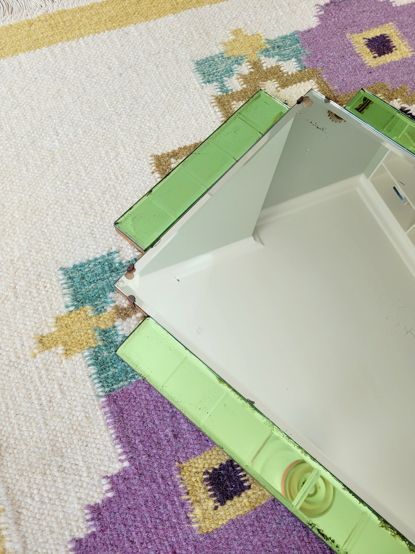 detail of an Art Deco green glass wall mirror