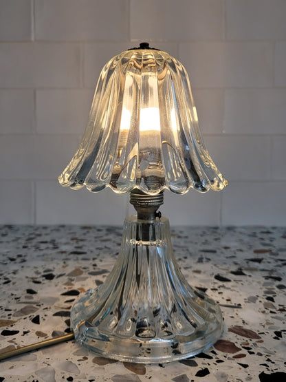front view of a clear Murano glass table lamp with scalloped shade