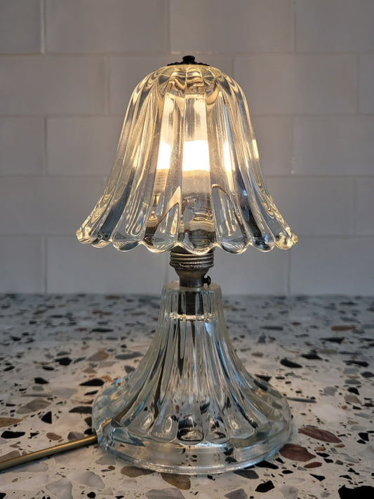 front view of a clear Murano glass table lamp with scalloped shade