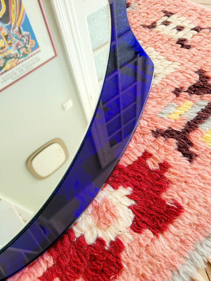 detailed view of a curved wall mirror with rich blue tone