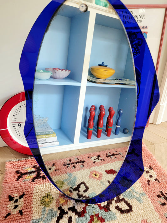 front view of a curved wall mirror with rich blue tone