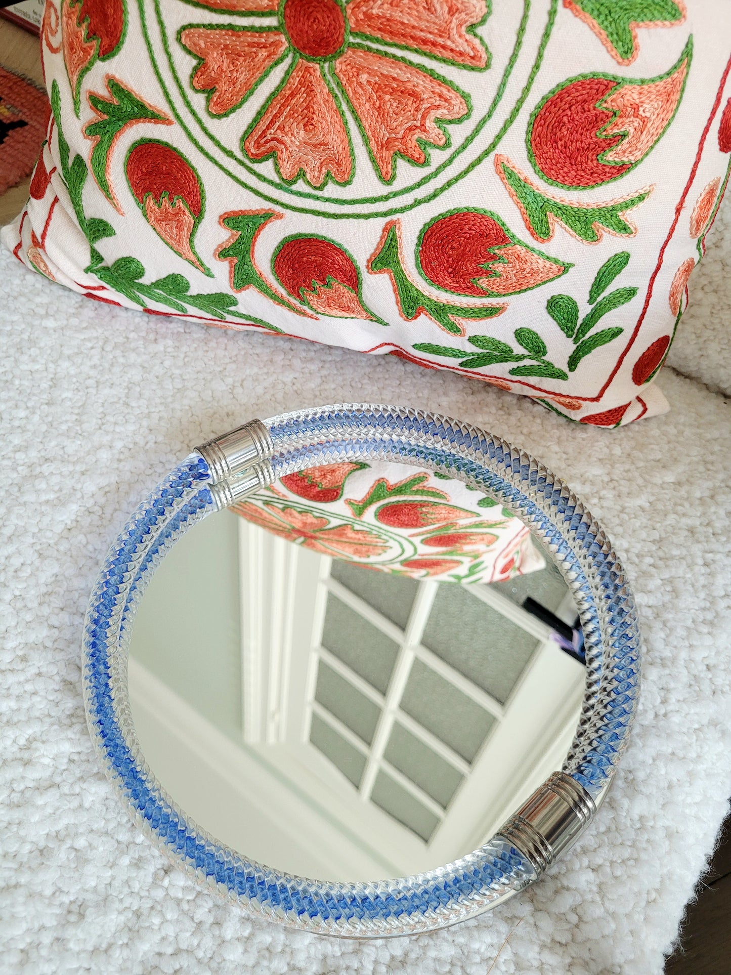 top view of a vintage Italian mirror with a twisted frame of vibrant blue Murano glass