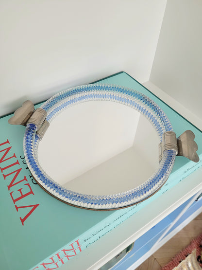 full view of an Italian mirror tray with twisted blue Murano glass frame on a stack of Venini books