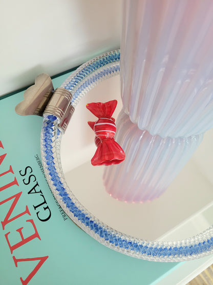 detail of an Italian mirror tray with twisted blue Murano glass frame on a stack of Venini books
