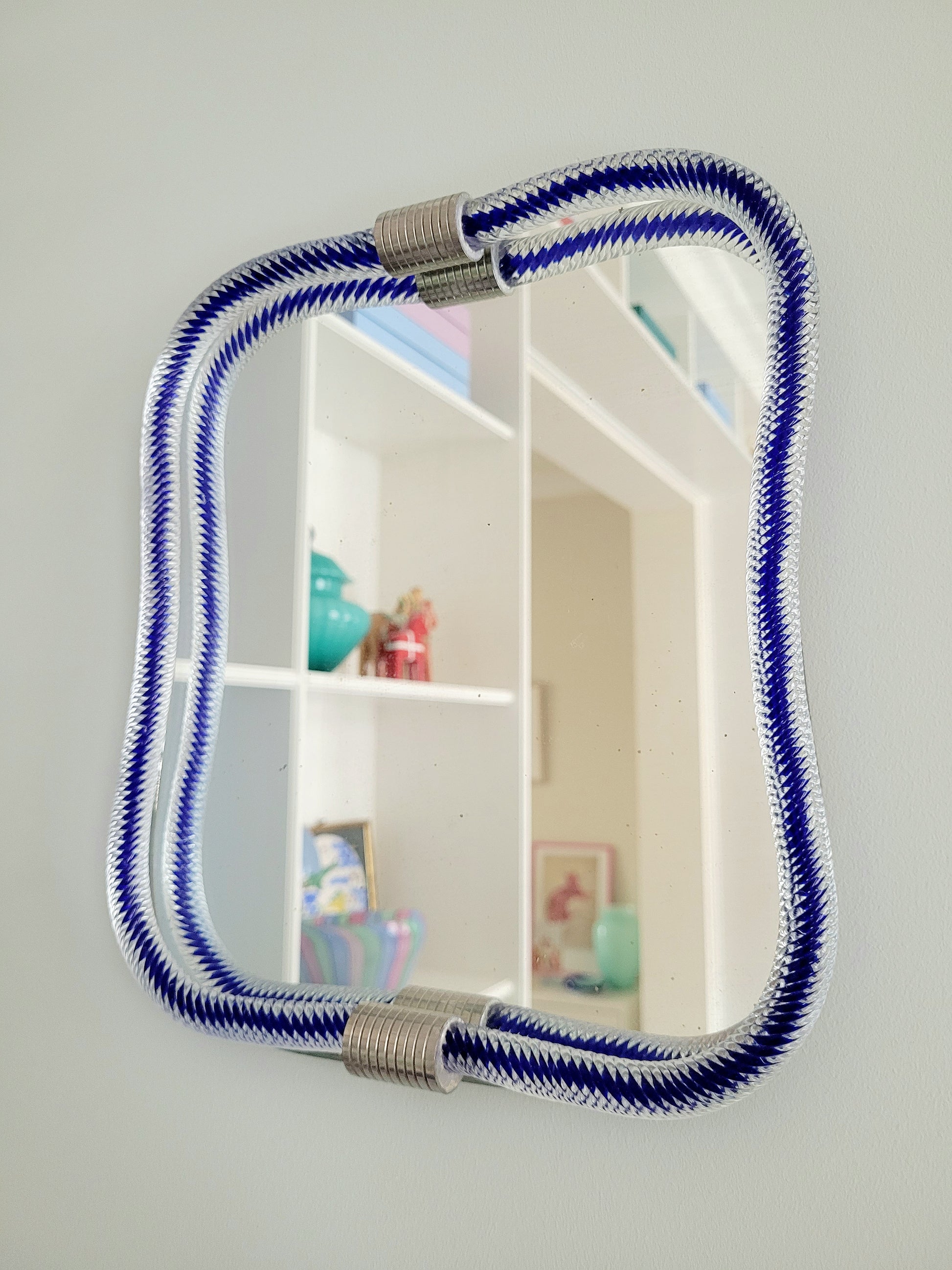 full view of a vintage Italian mirror, accentuated by a twisted frame of clear/blue Murano glass