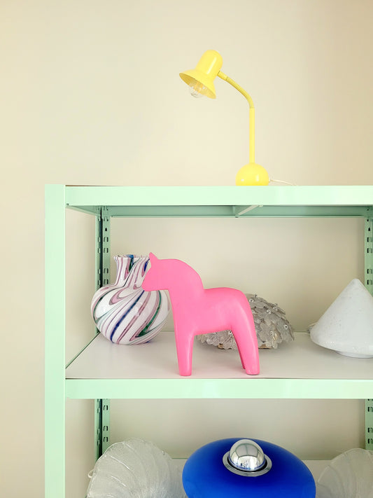 full view of a large pink wooden Dala horse on a shelf with other vintage items