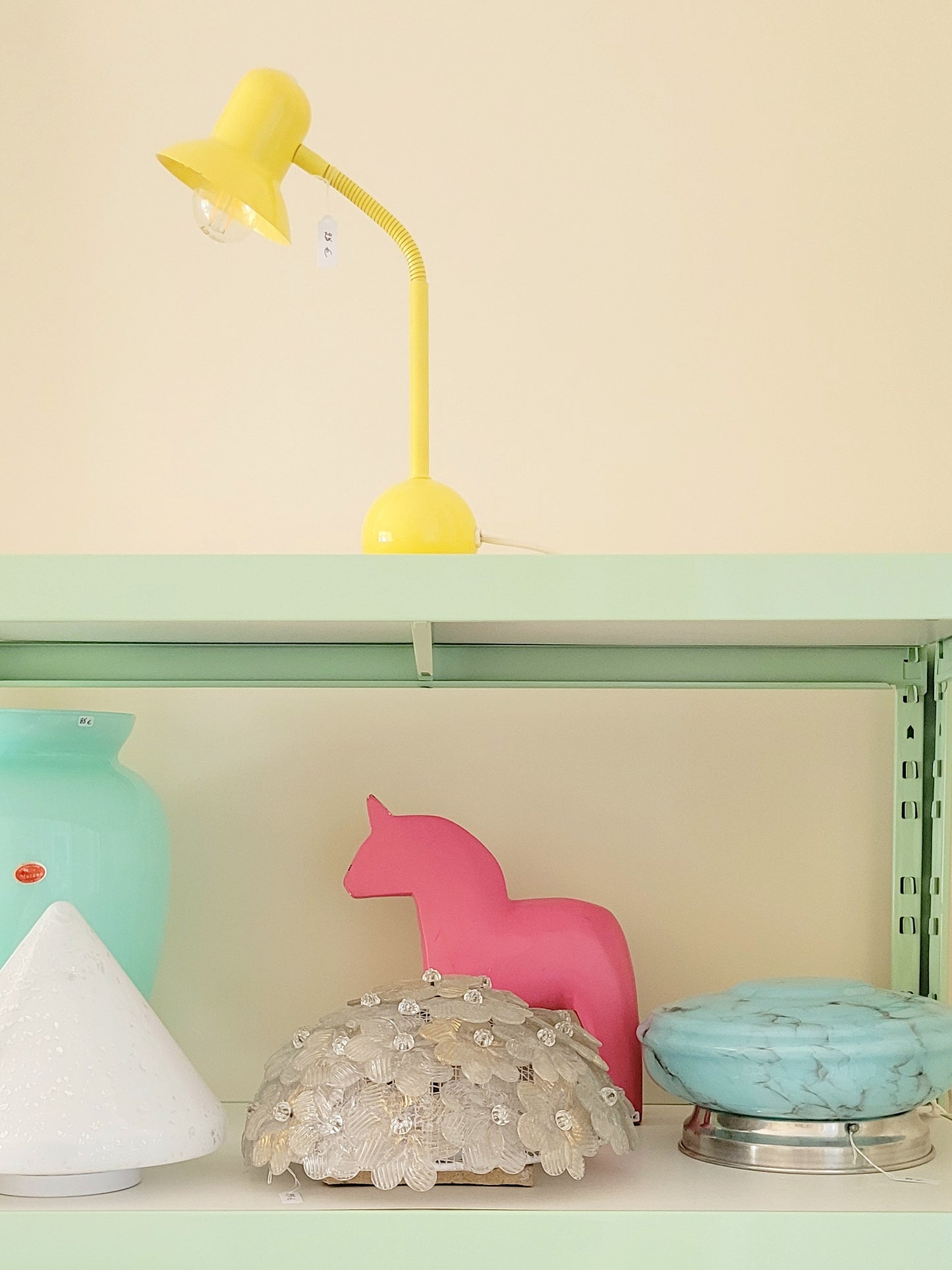 full view of a large pink wooden Dala horse on a shelf with other vintage items
