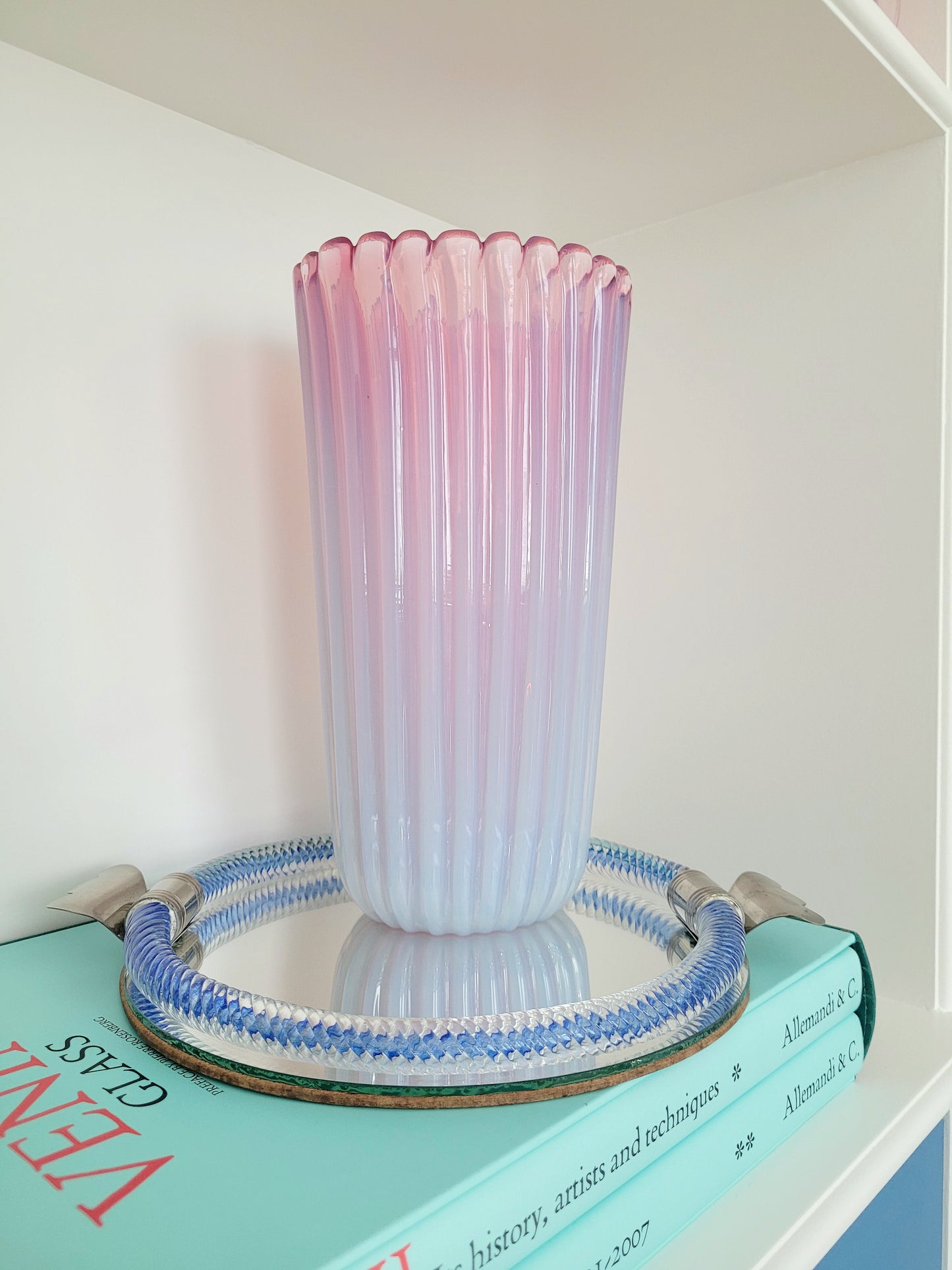 a large vintage pink ribbed Murano vase on a vintage Murano mirror tray and a stack of Venini books