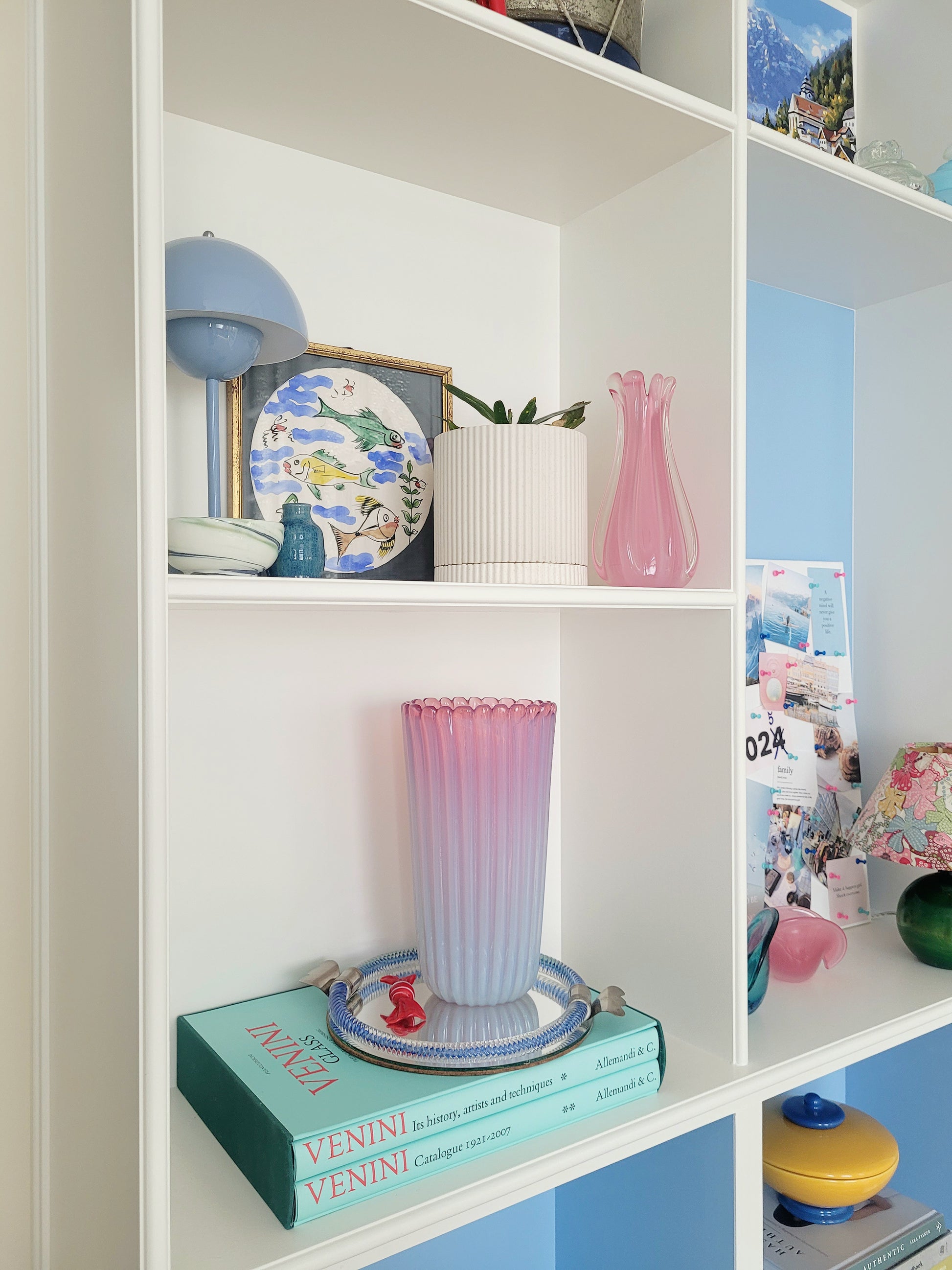 a large vintage pink ribbed Murano vase on a vintage Murano mirror tray and a stack of Venini books