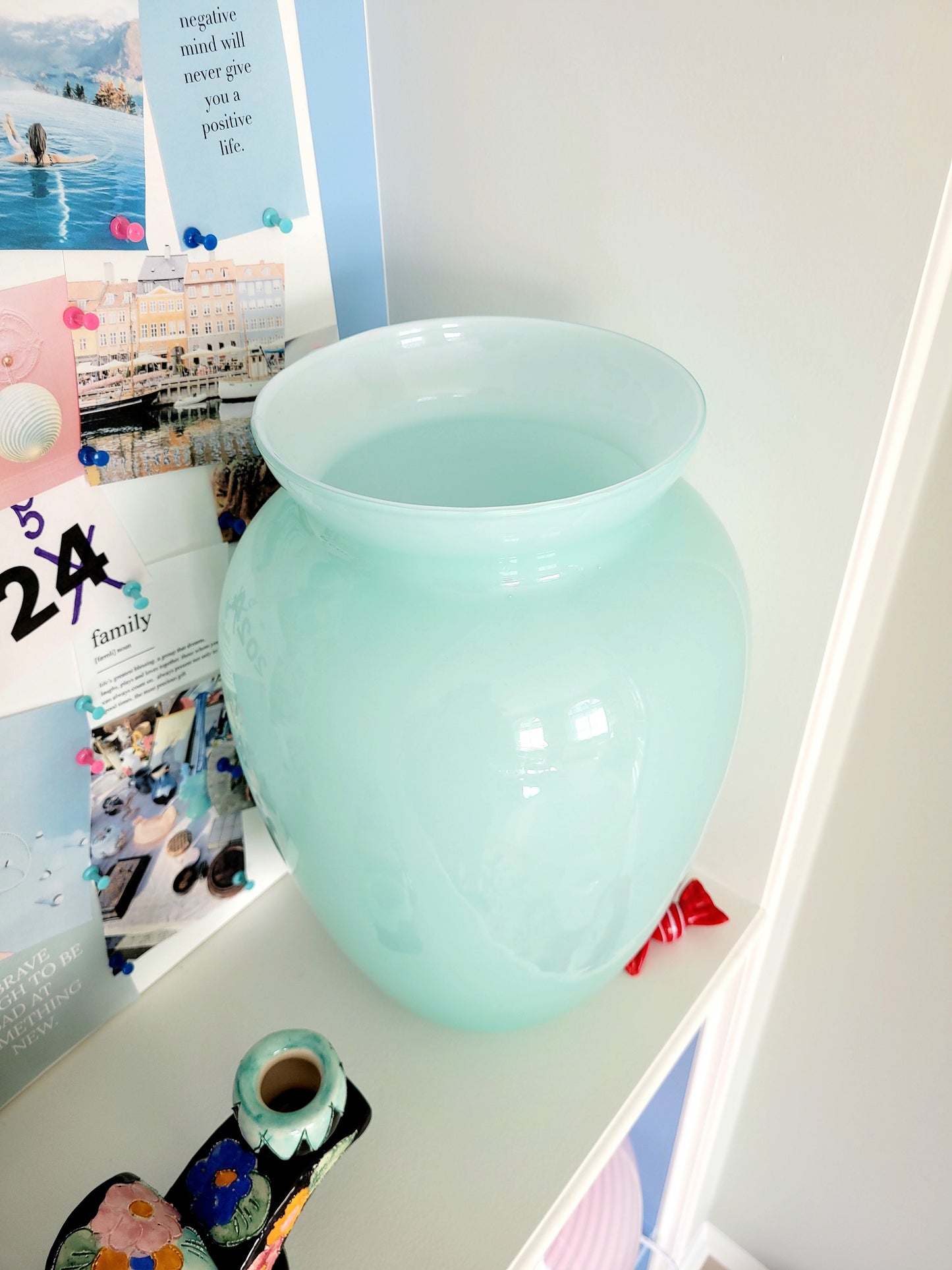 full view of a vintage Murano vase with a glossy aquamarine-mint green exterior over a soft milk-white opaline interior