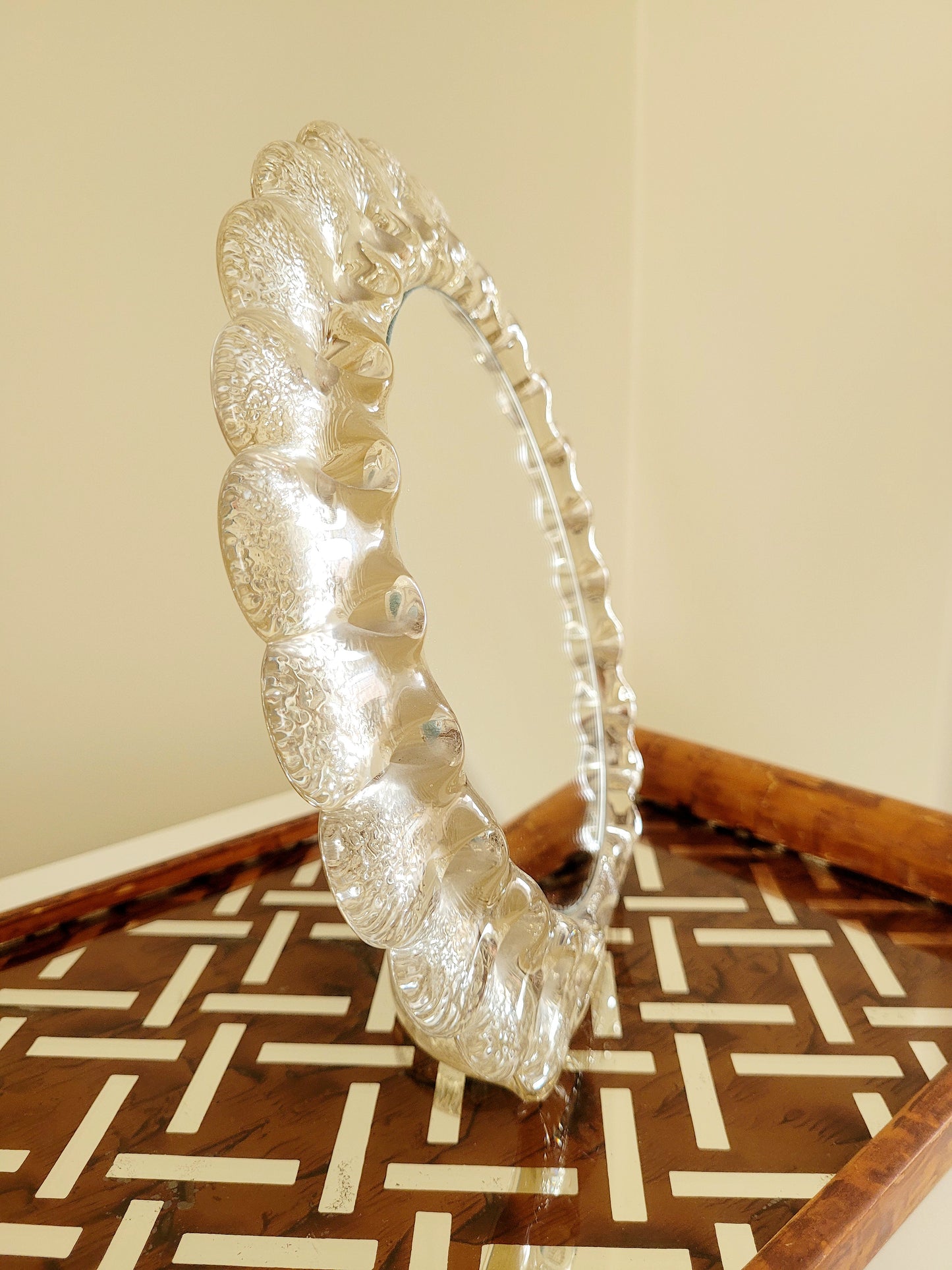 side view of a vintage Murano glass table mirror featuring a heavy, beautifully textured clear glass frame with a dramatic scalloped silhouette