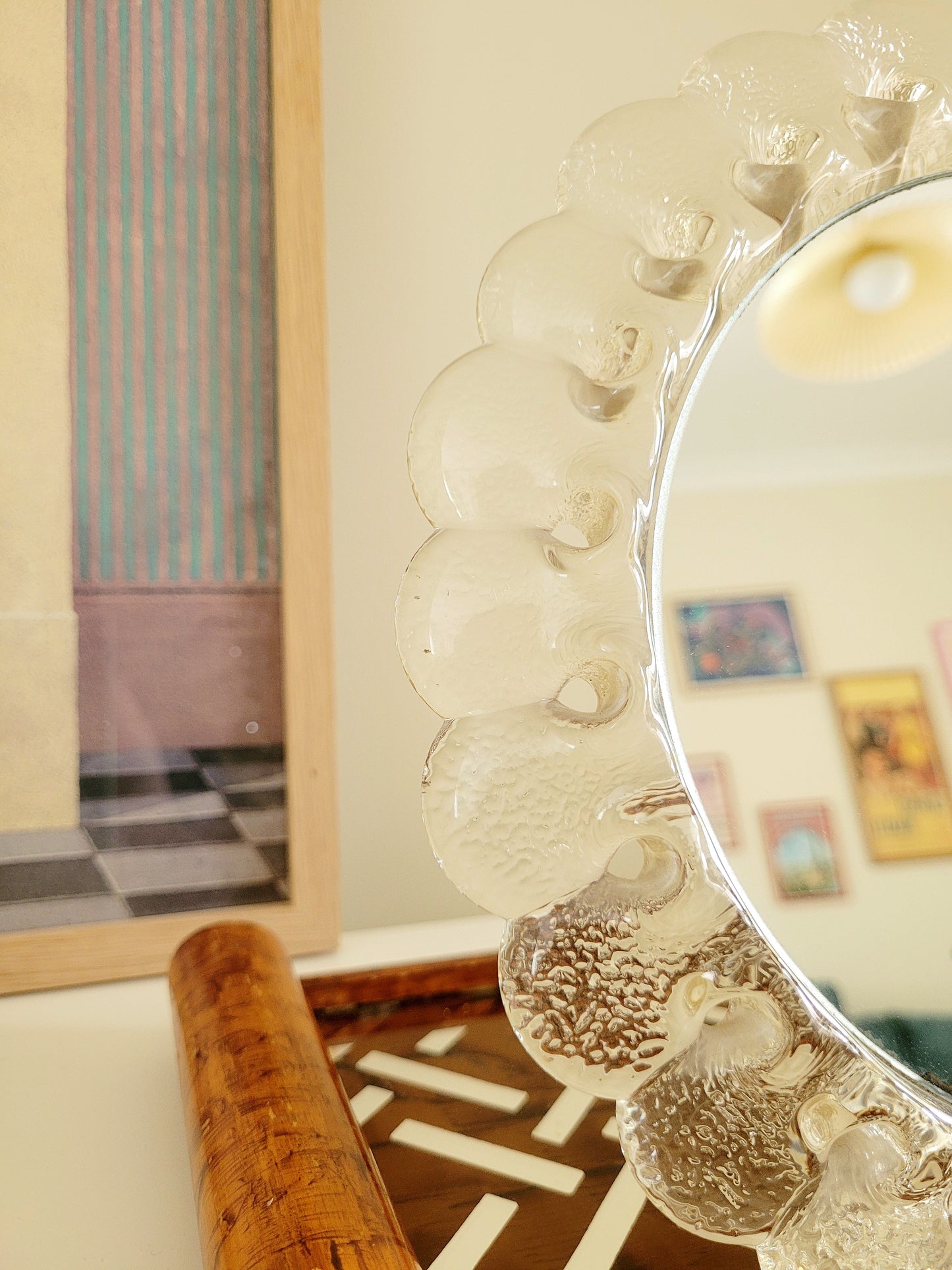 detail of a vintage Murano glass table mirror featuring a heavy, beautifully textured clear glass frame with a dramatic scalloped silhouette