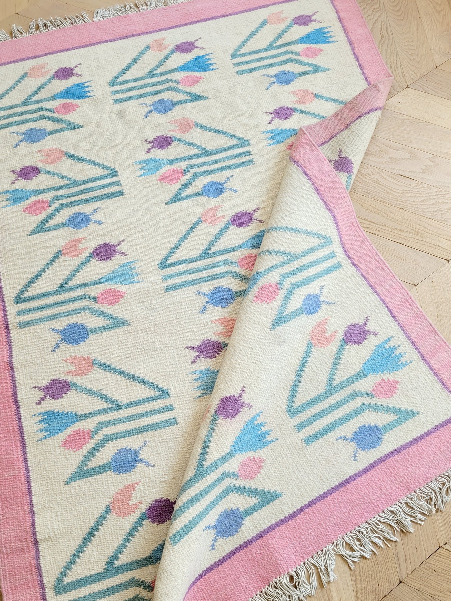 top view of a pink and pastel coloured vintage rug with floral pattern