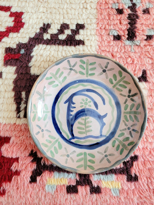 small French wall plate depicting a doe and made by François Miro for Sant Vicens Ceramics, Perpignan, France. Blue and green colours. The plate is on a colourful rug.