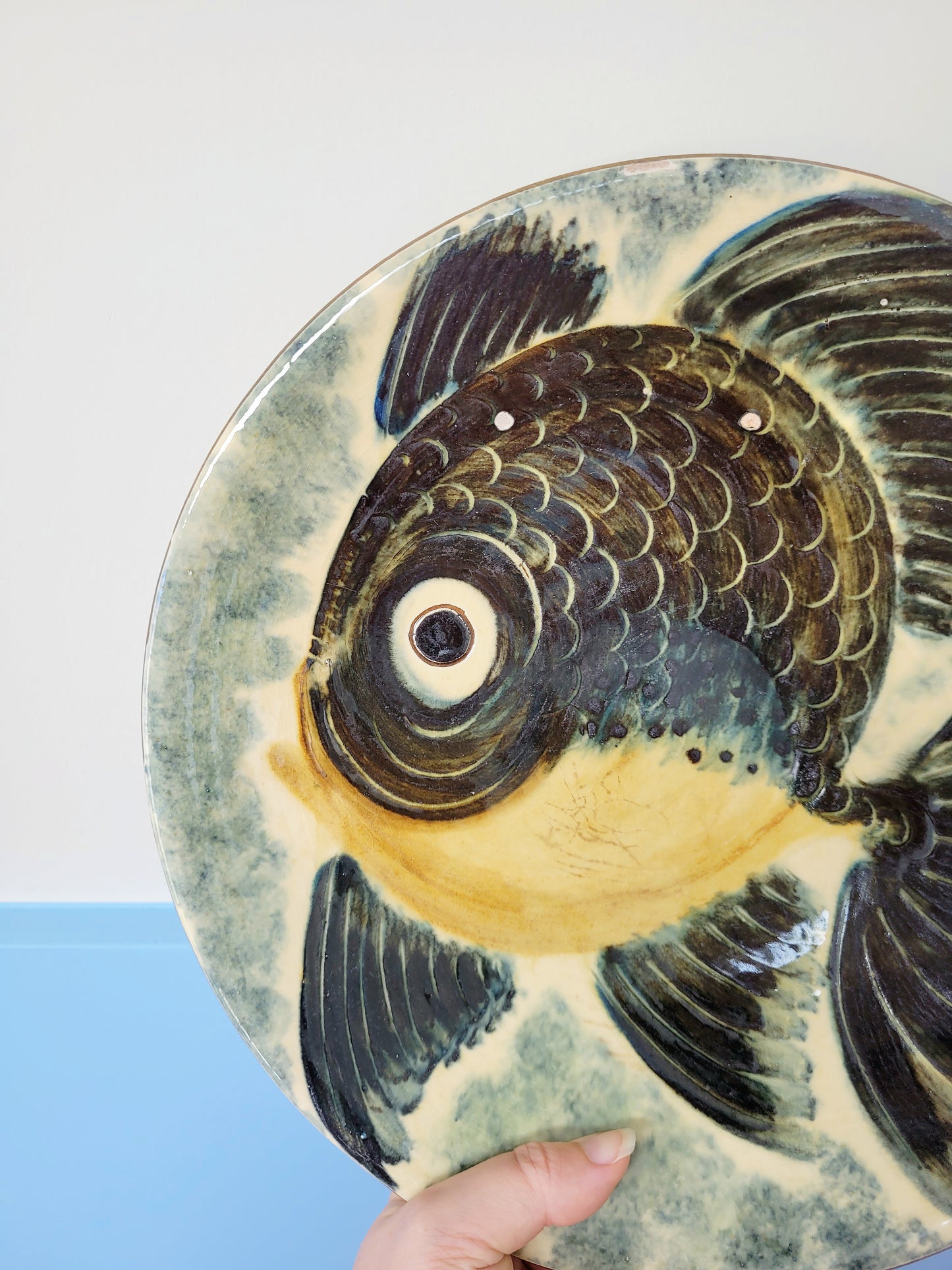 detail of a spanish Puigdemont fish wall plate in greens and yellow