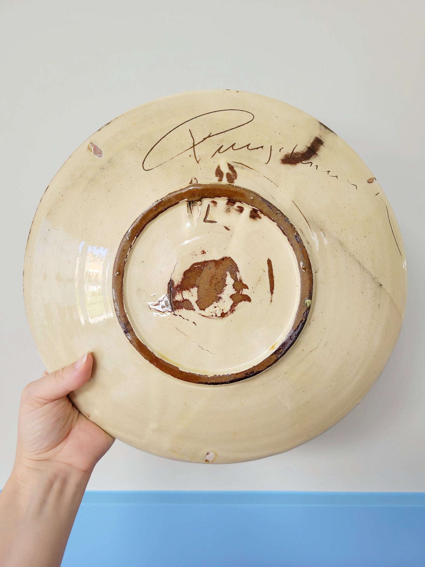 back view of a signed spanish Puigdemont fish wall plate in greens and yellow