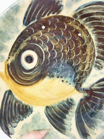 detail of a spanish Puigdemont fish wall plate in greens and yellow
