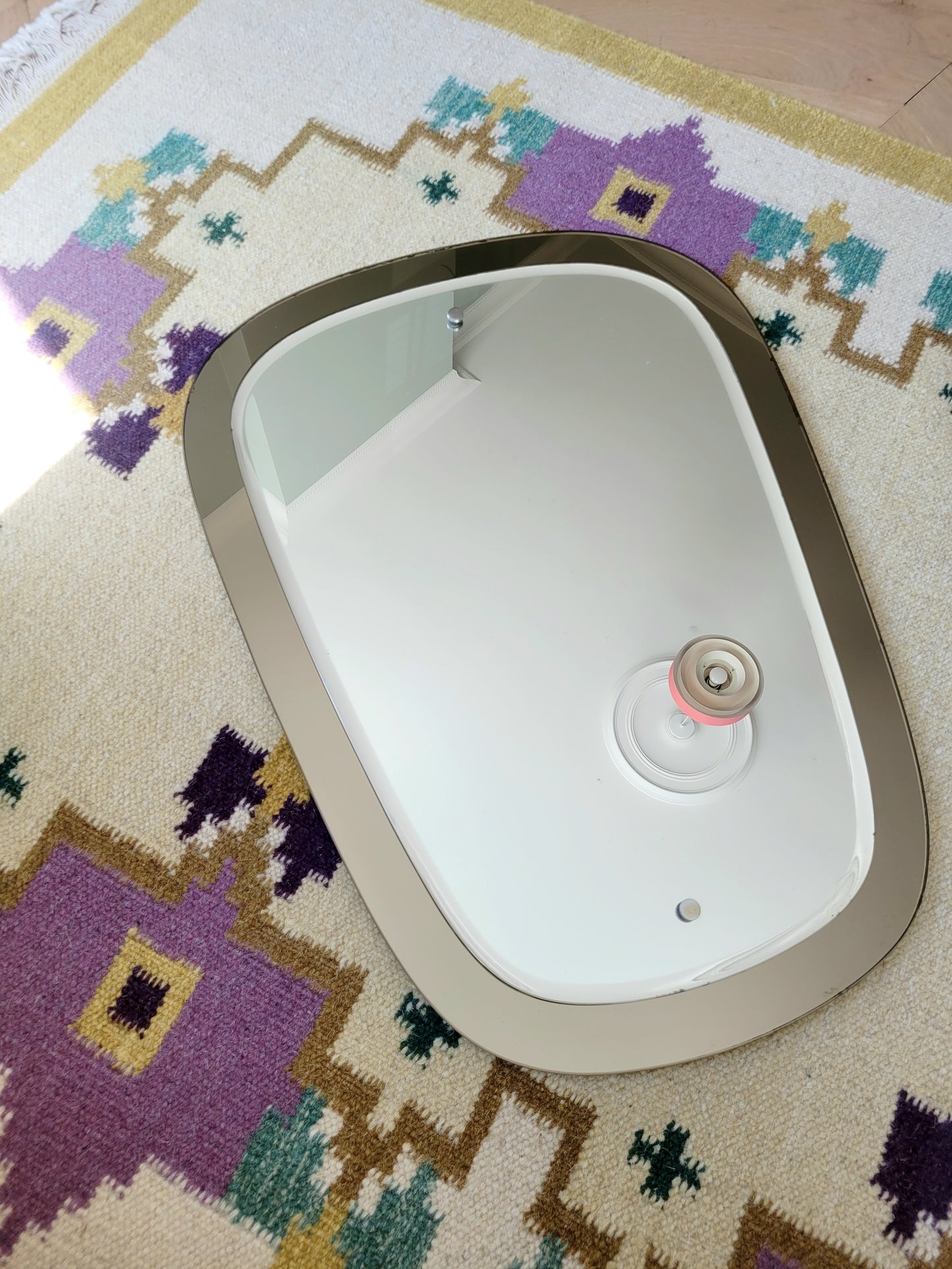  top view of a two-tone Italian mirror featuring smoked glass edging 