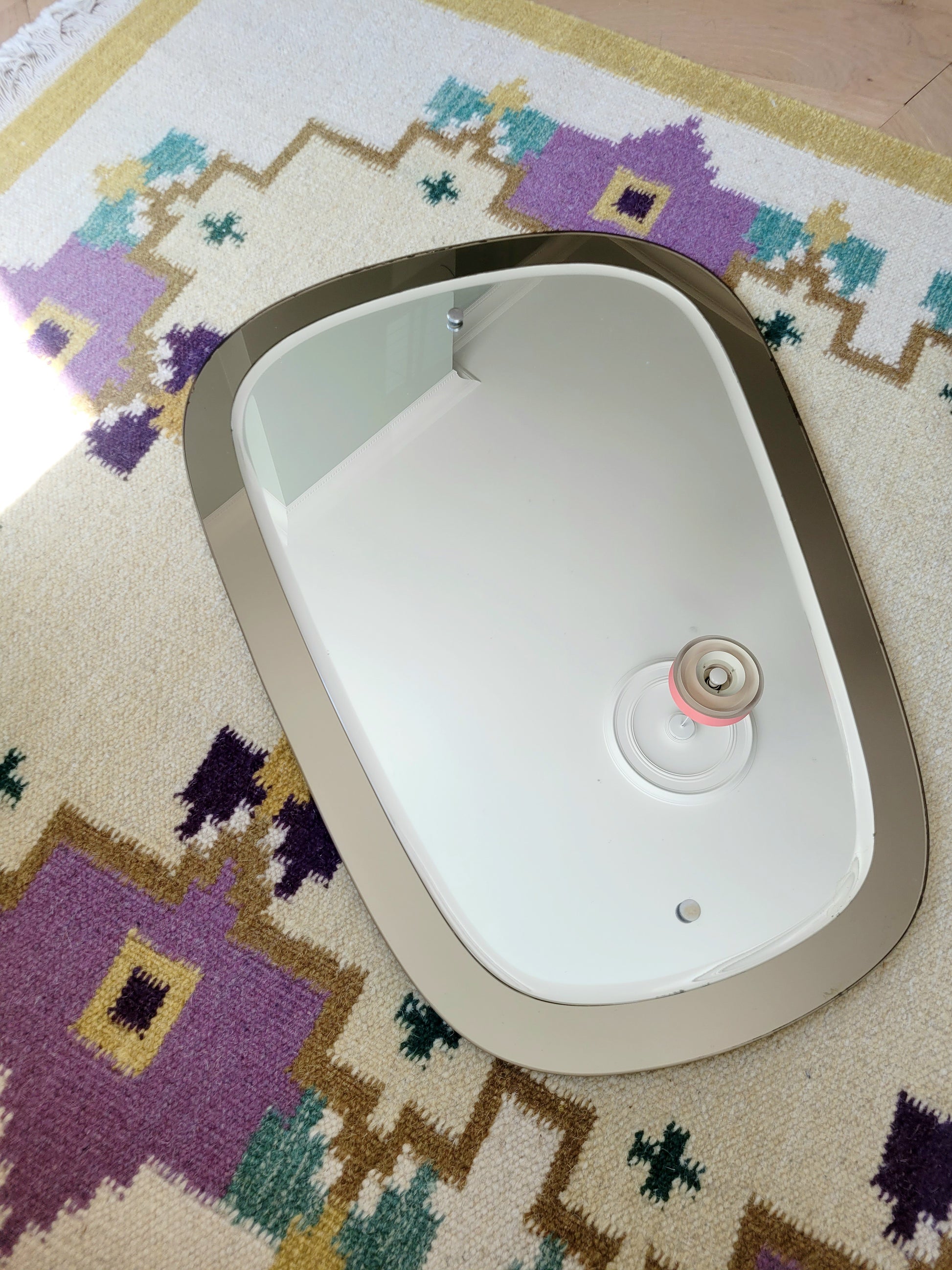  top view of a two-tone Italian mirror featuring smoked glass edging 