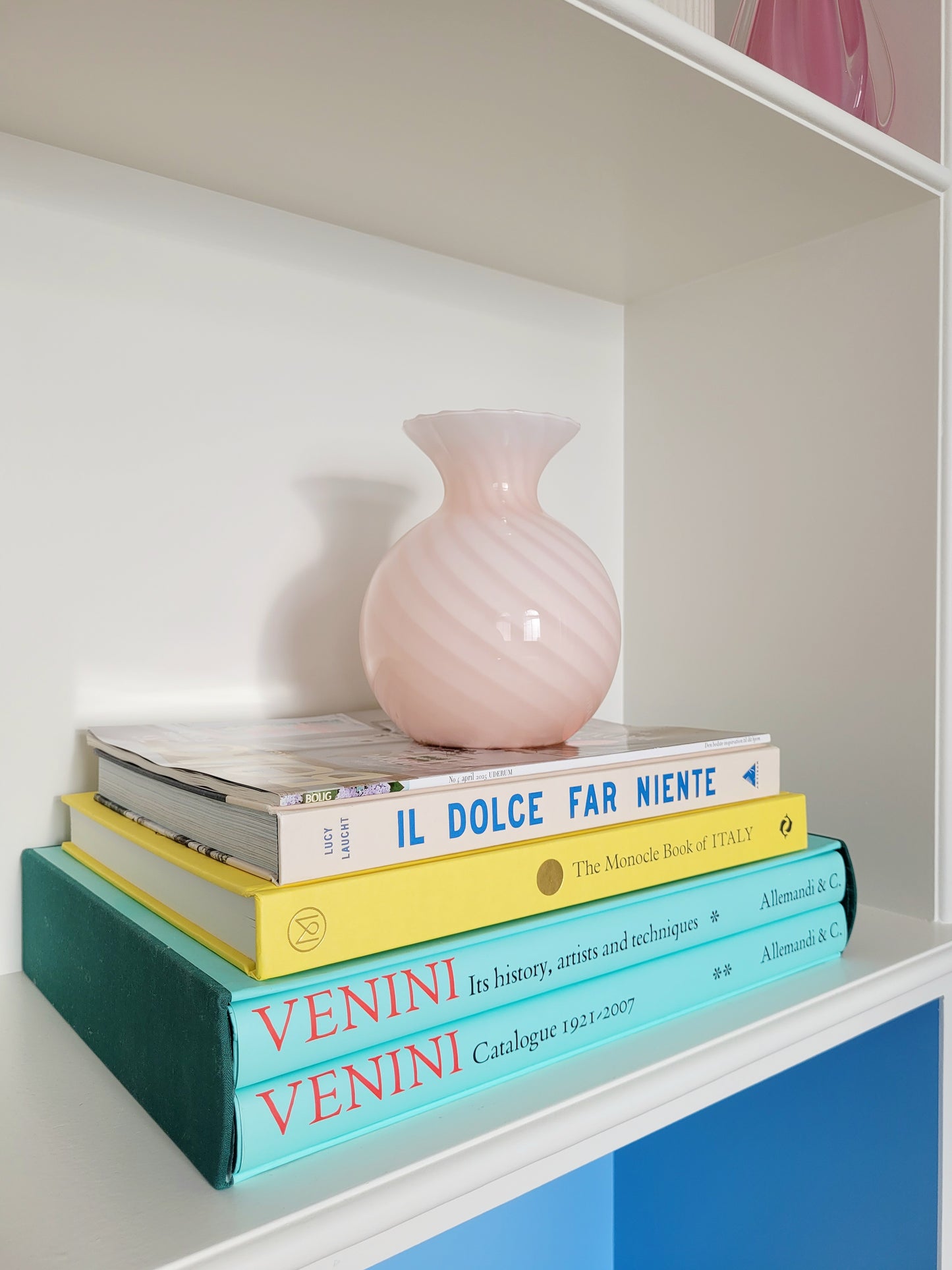 a vintage Murano pink swirl vase on a stack of colourful books