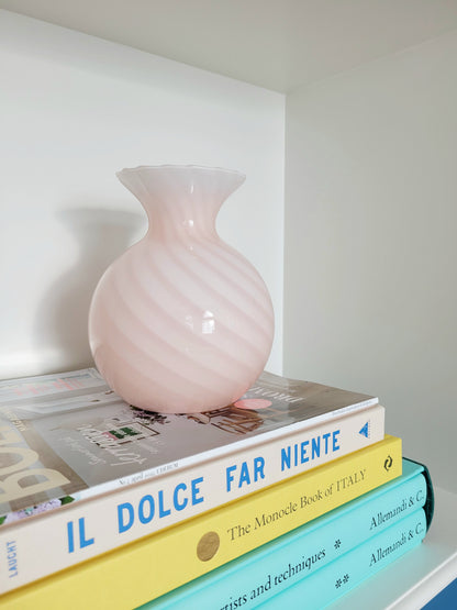 detail of a vintage Murano pink swirl vase on a stack of colourful books