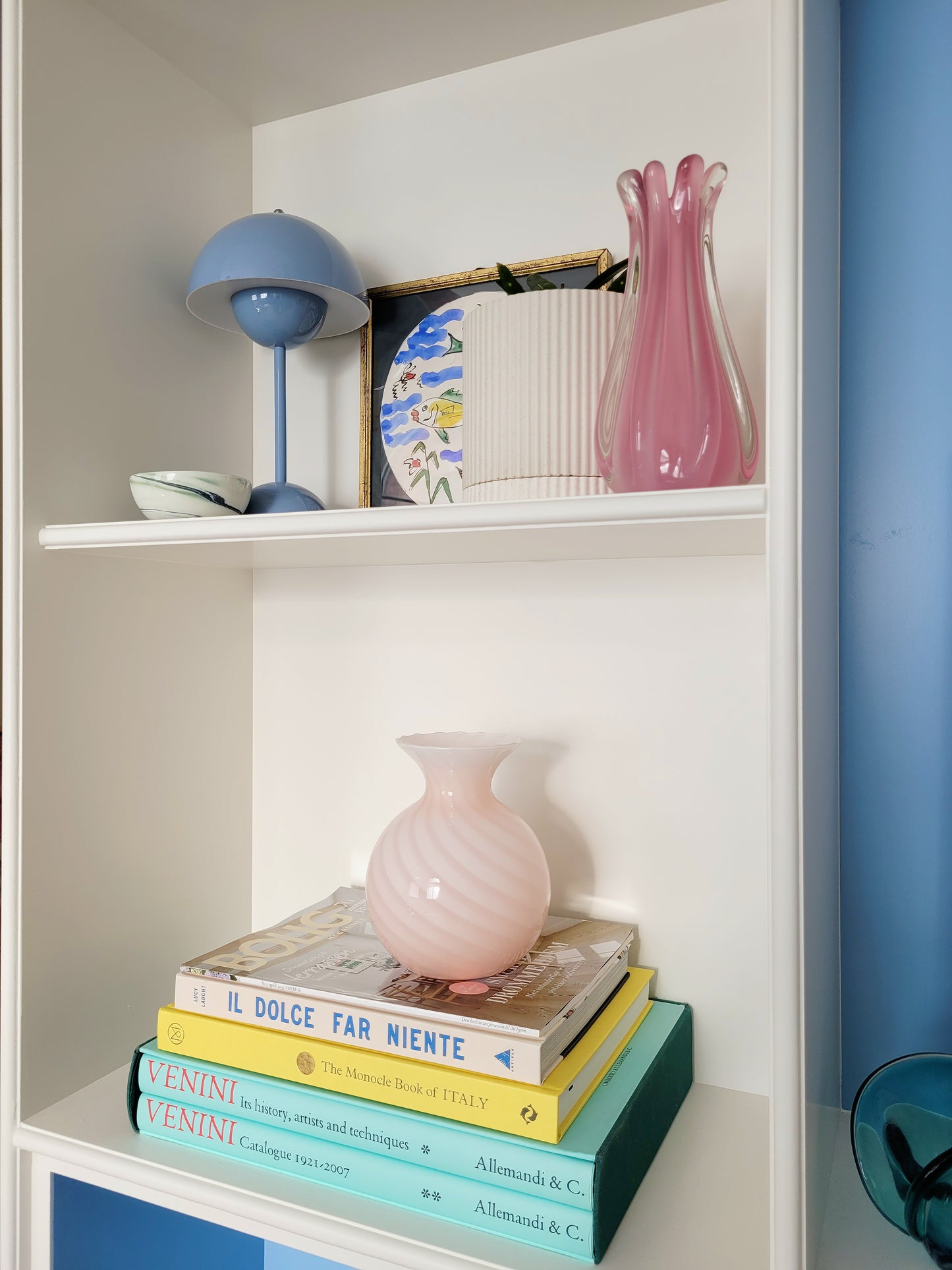 a vintage Murano pink swirl vase on a stack of colourful books