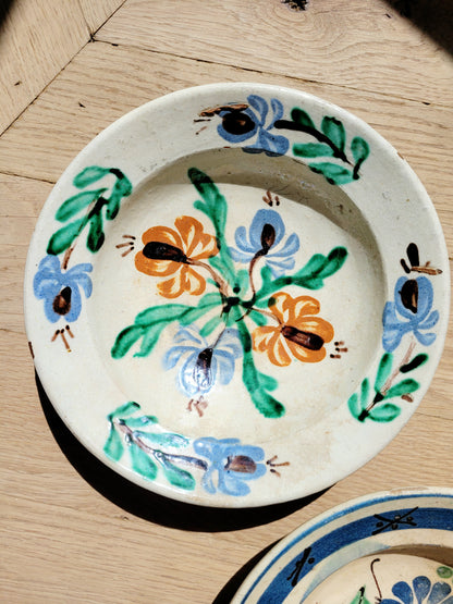 hand-painted earthenware wall plate/bowl from Romania-Hungary with floral design on a parquet floor, typical folk art